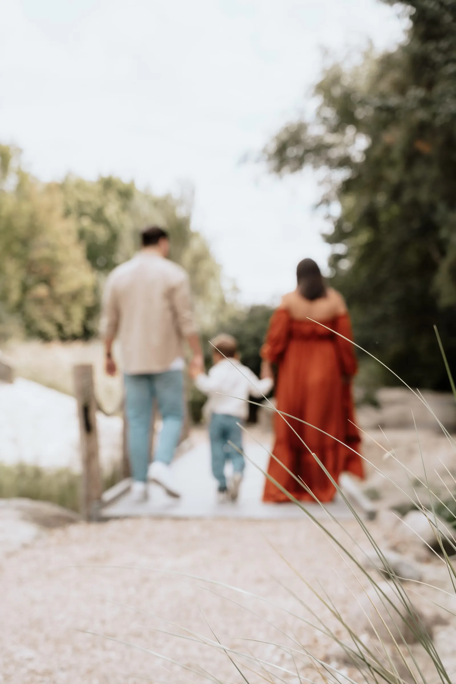 Familie auf einem Waldweg, im Vordergrund das rostrote Kleid