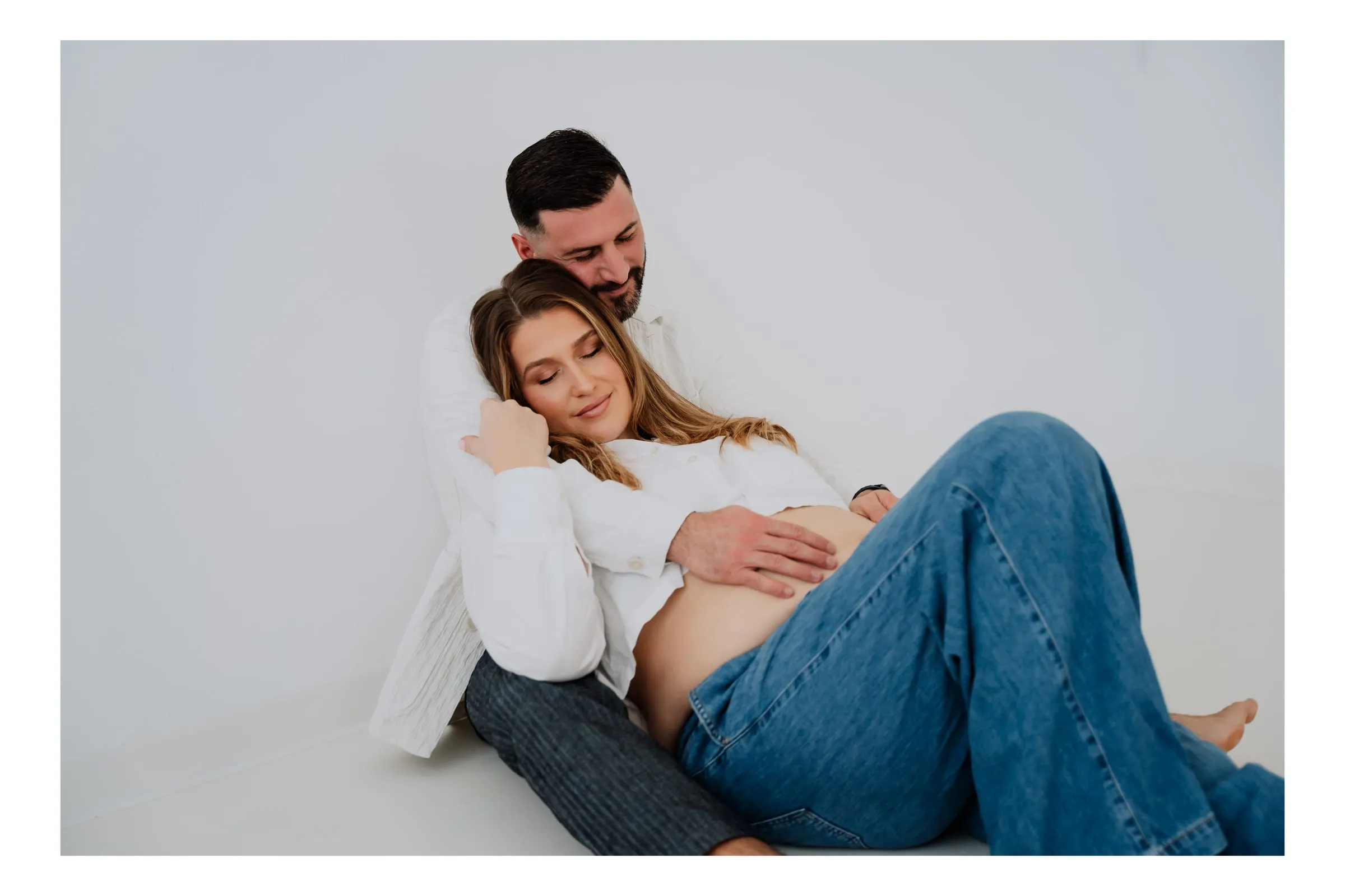 Sie lehnt sich im Sitzen an ihn, beide in Jeans