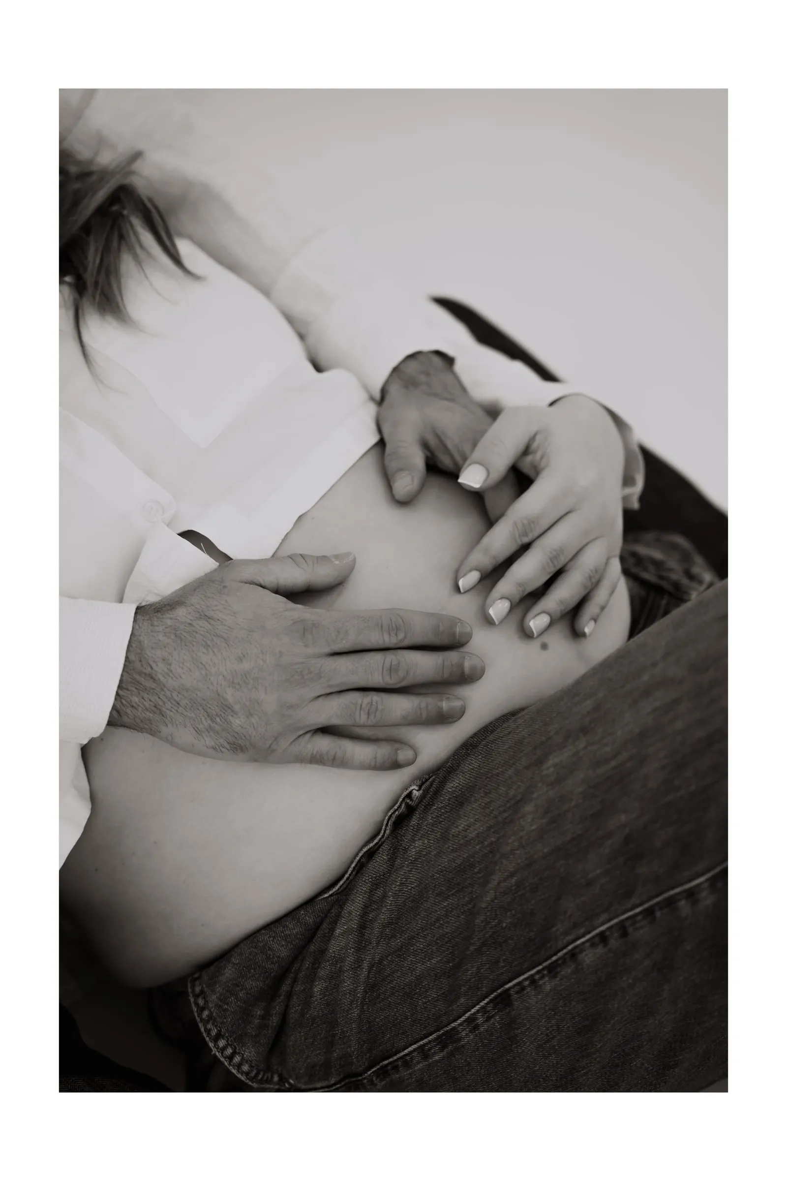 Hände auf dem nackten Babybauch, in Schwarzweiß