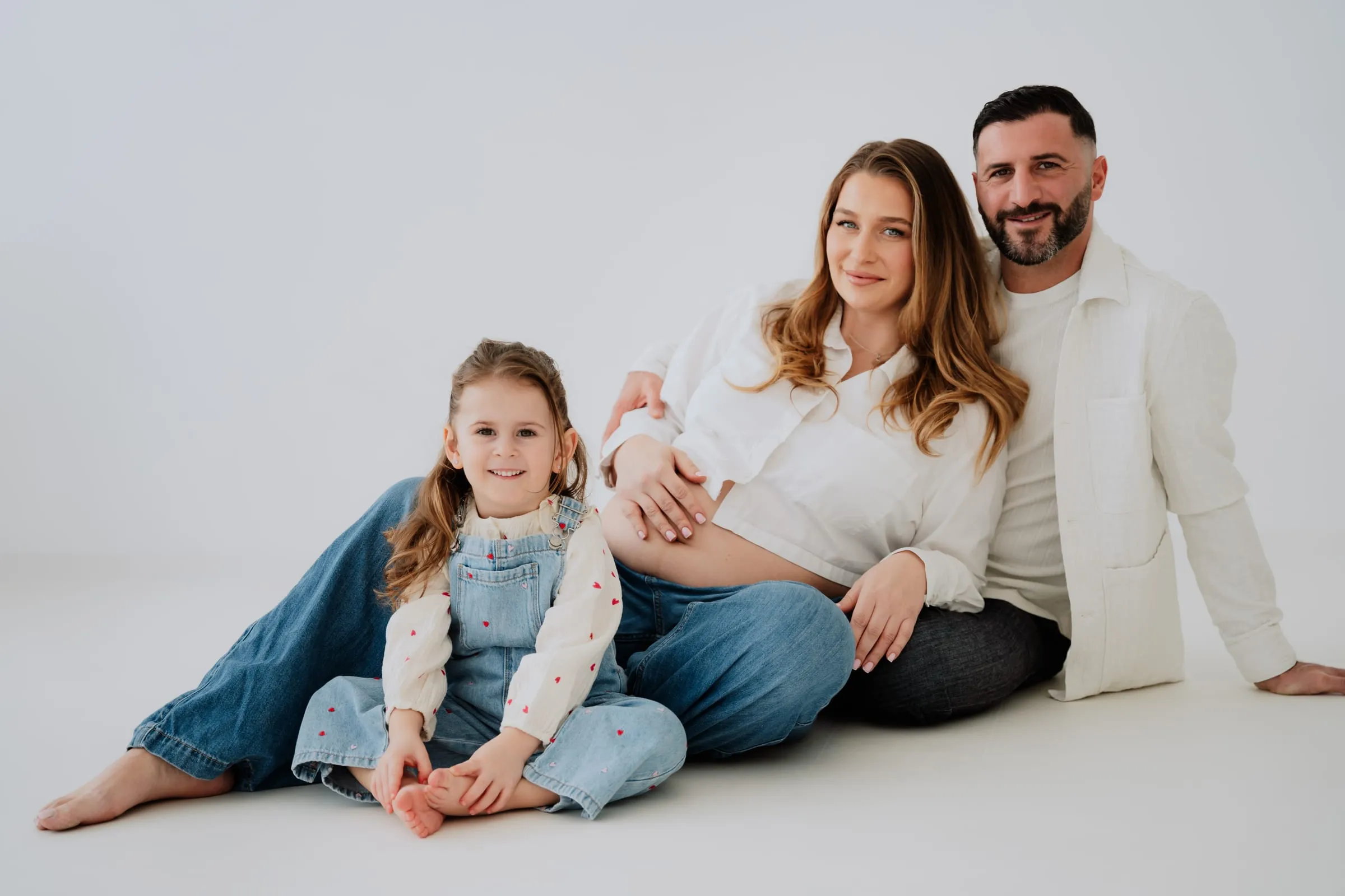Die Familie sitzt gemeinsam auf dem Studioboden