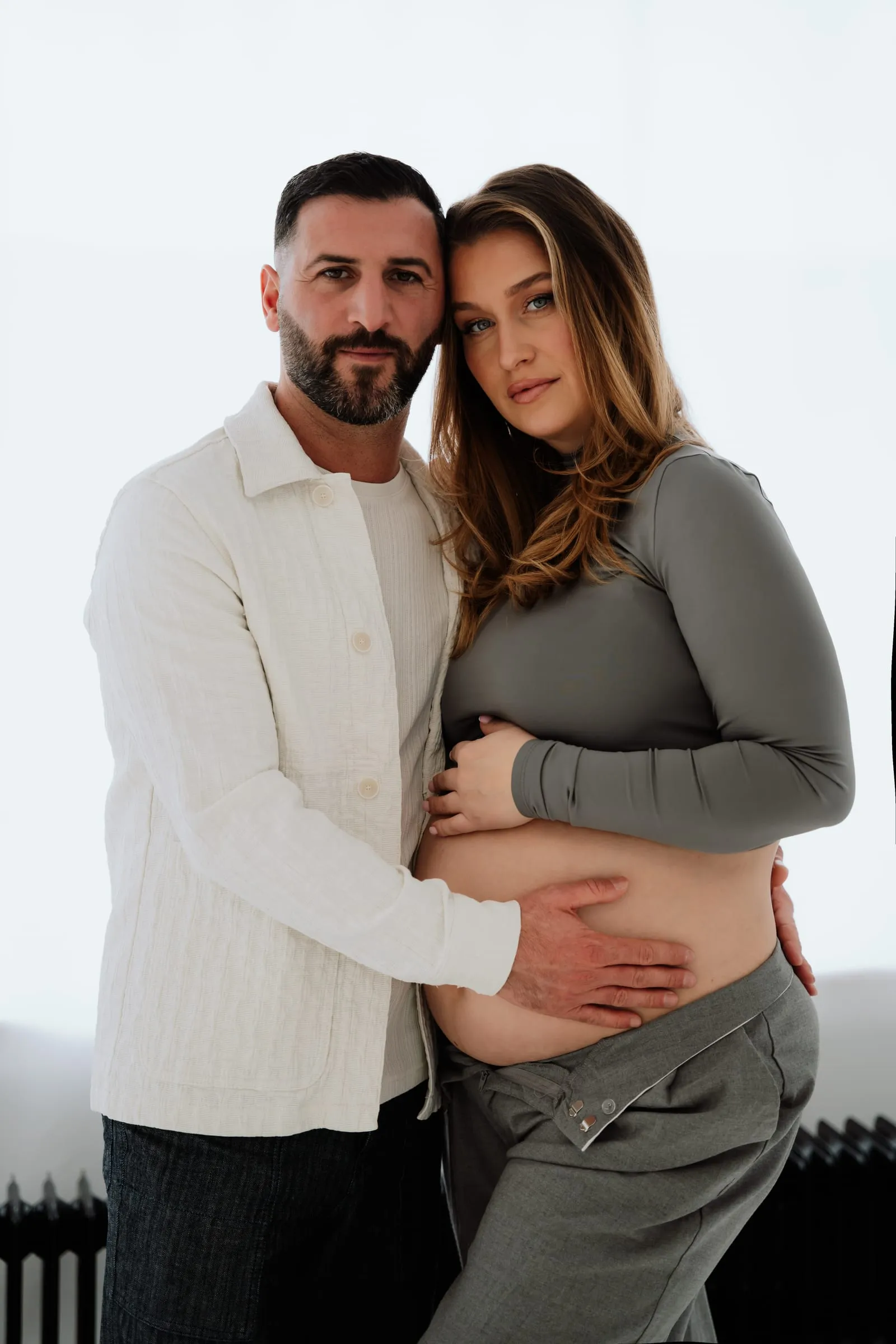 Das Paar hält gemeinsam den Babybauch
