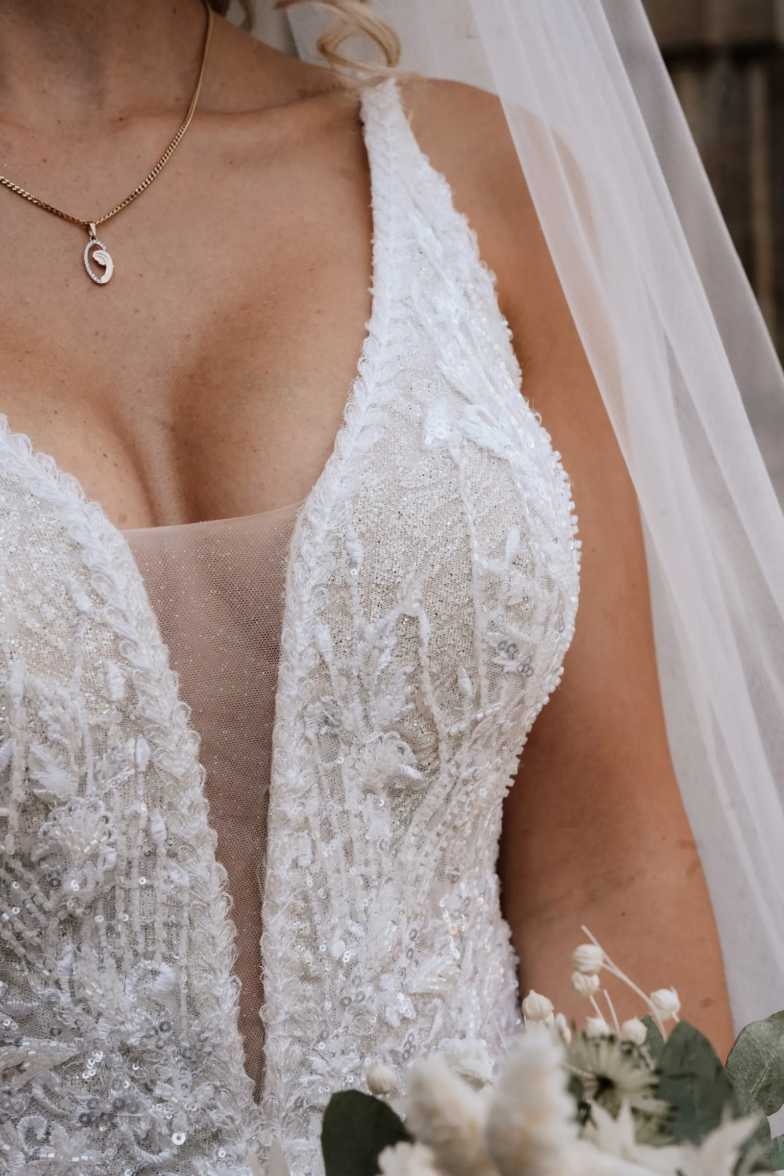 Detail des Spitzenkleides mit Kette und Schleier