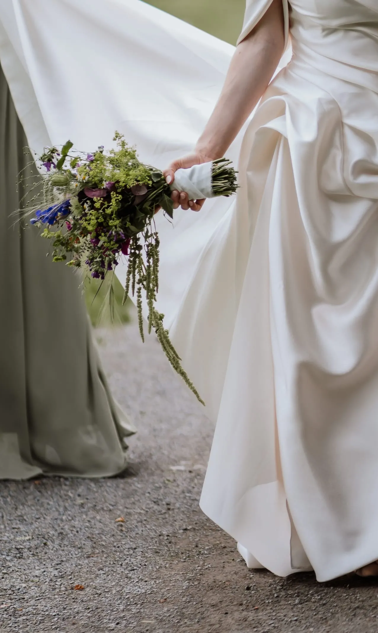 Der Wiesenstrauß in ihrer Hand vor dem Kleid
