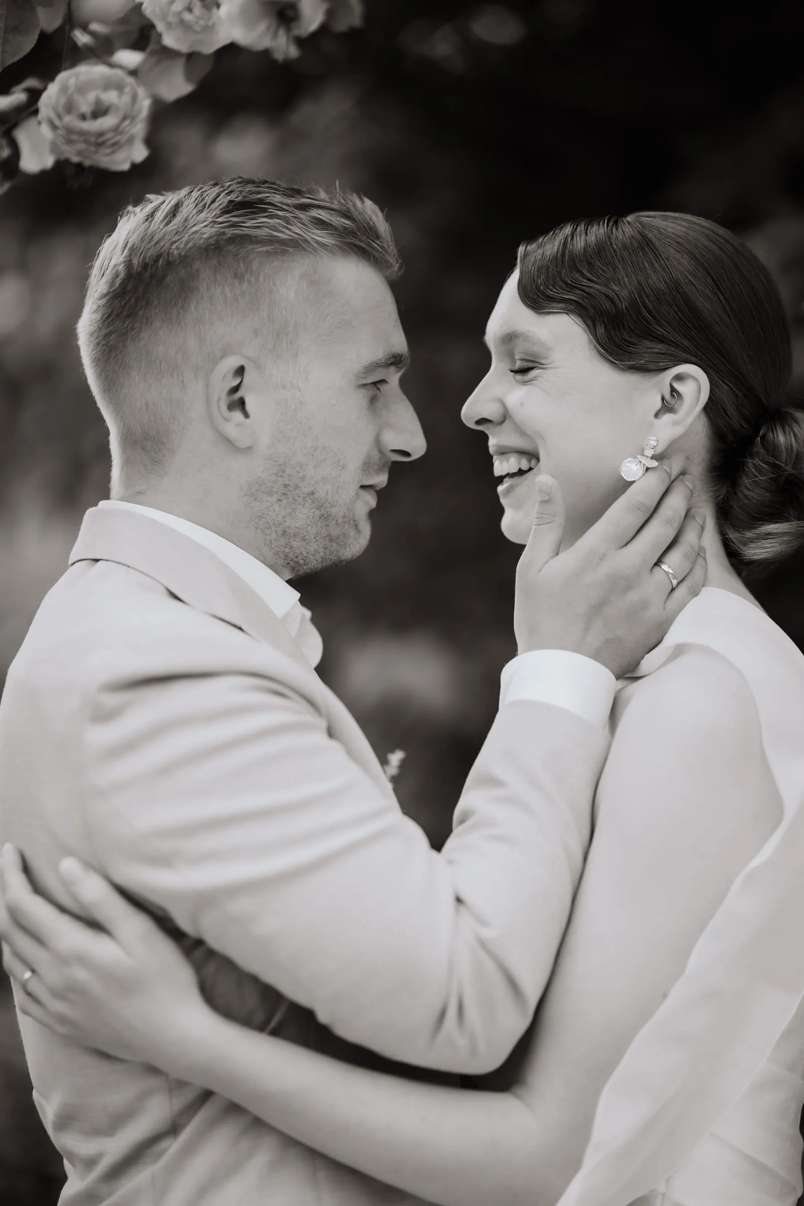 Sie hält sein Gesicht, beide lachen, in Schwarzweiß