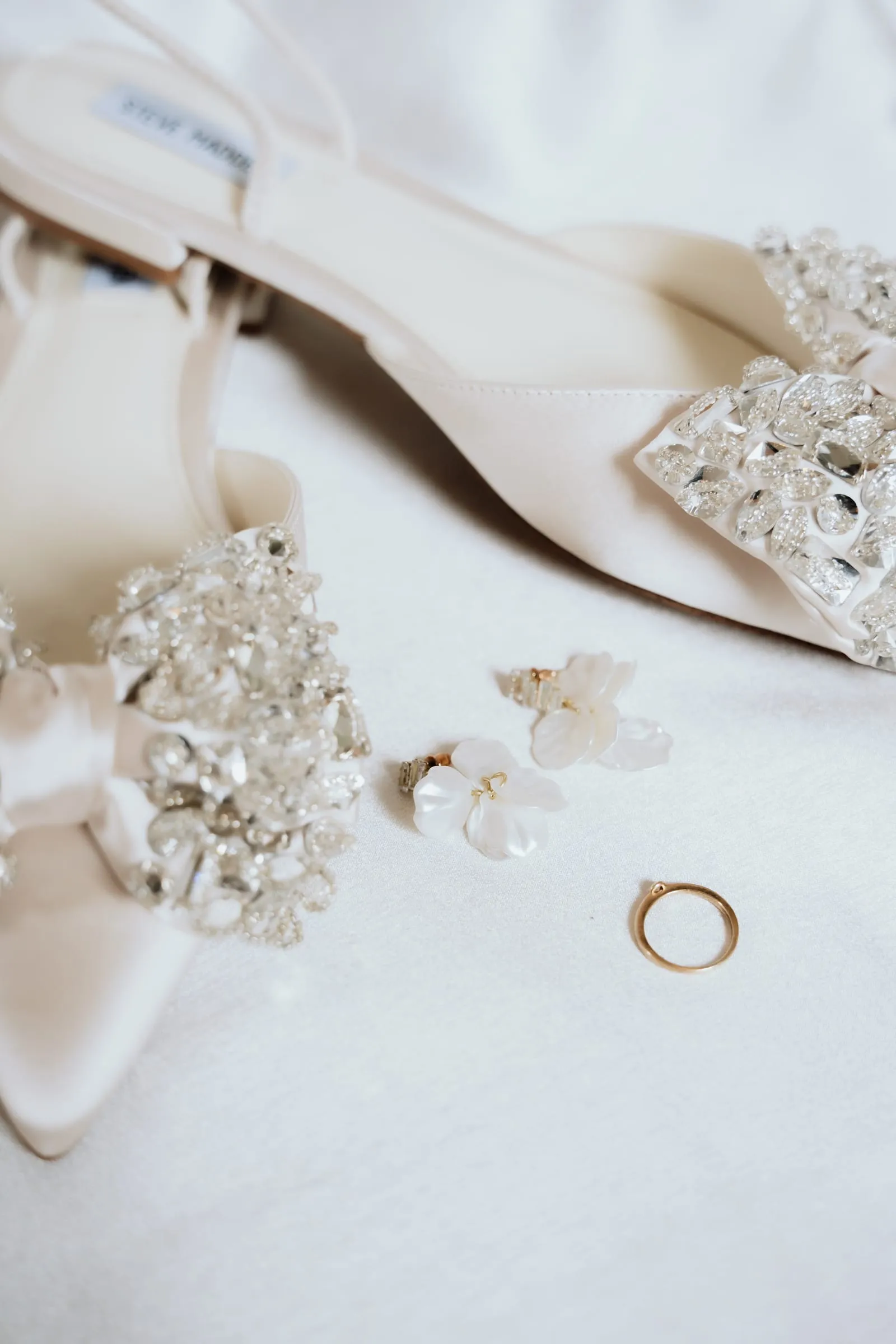 Schuhe, Schmuck und Ehering auf hellem Untergrund