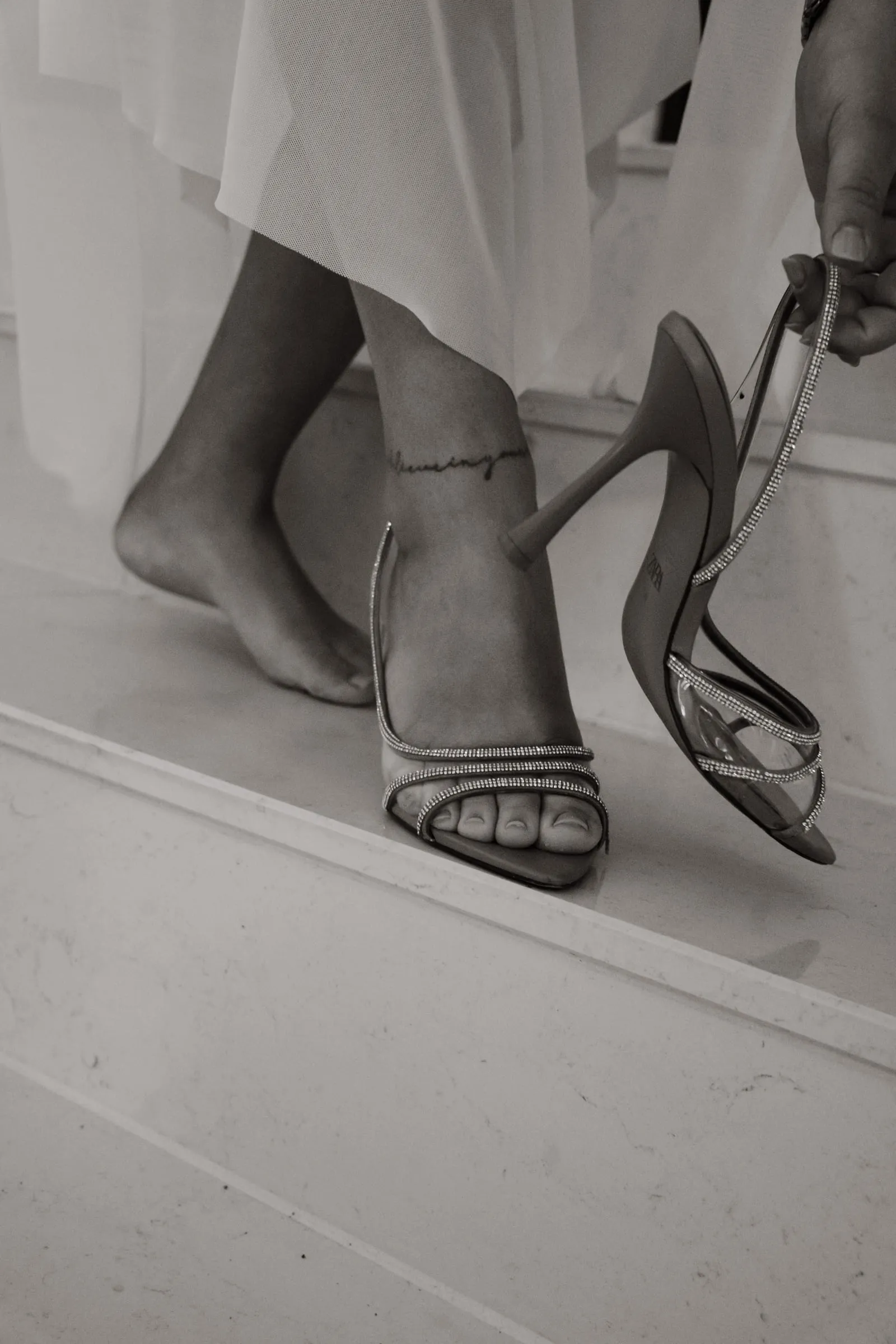 Die Braut steigt in ihre Schuhe, in Schwarzweiß
