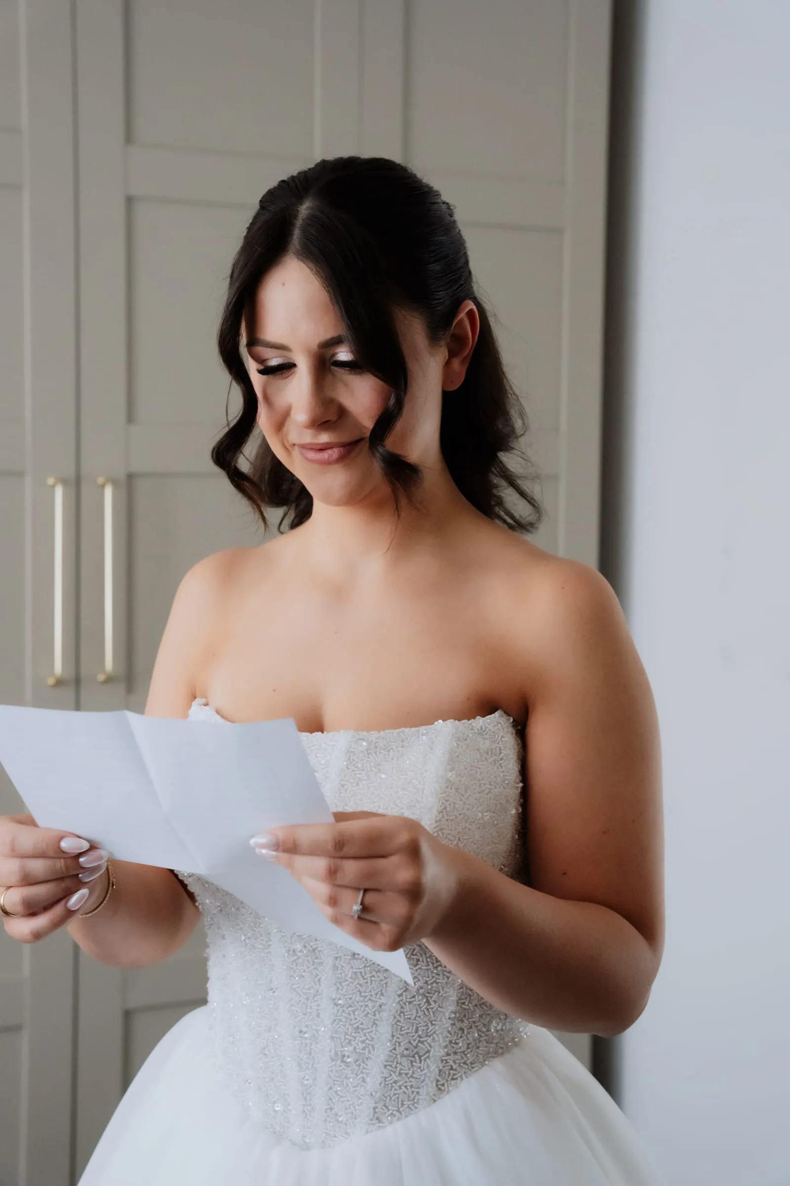Die Braut liest einen Brief, schon im Kleid
