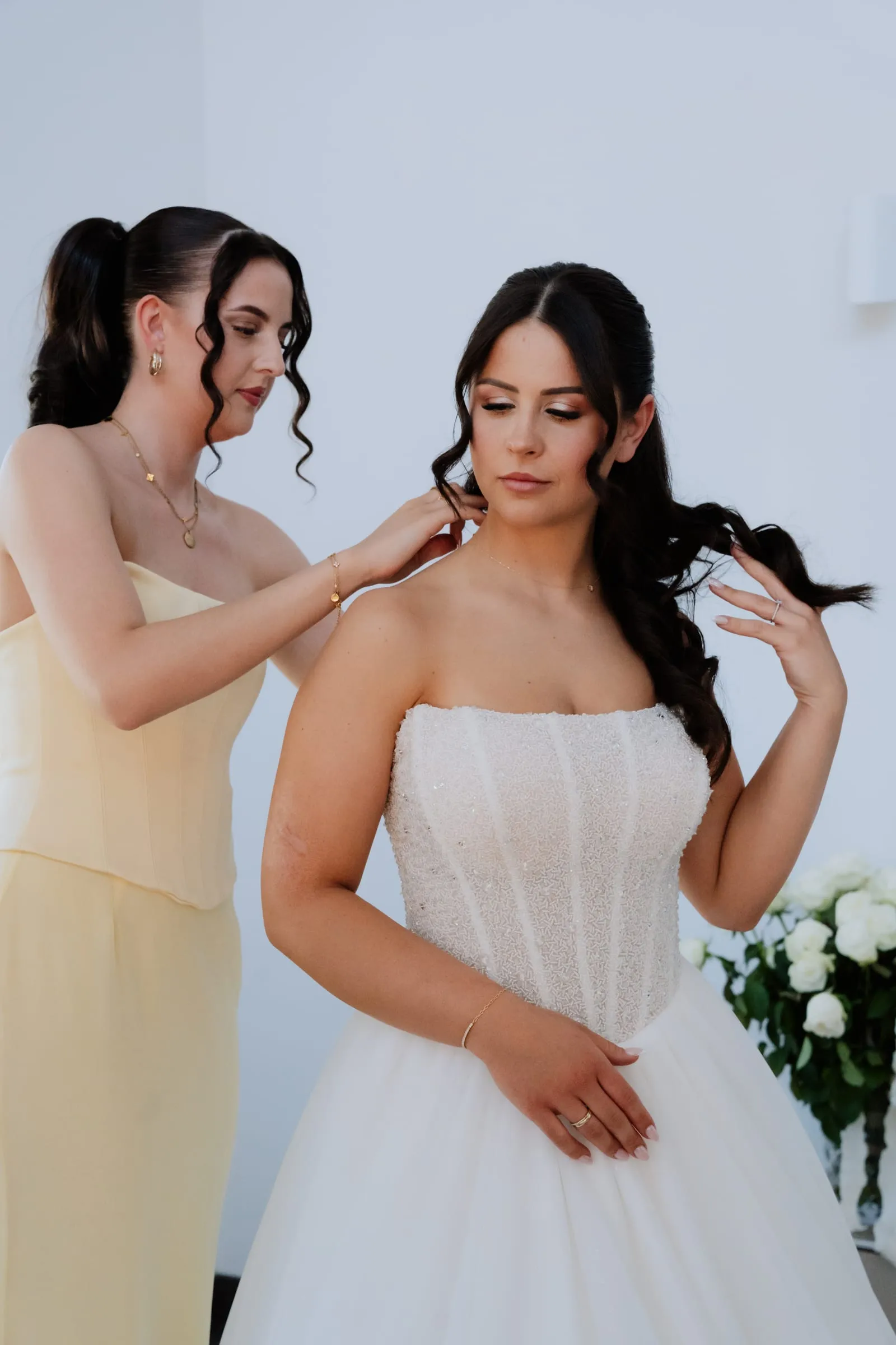 Eine Freundin richtet der Braut das Kleid