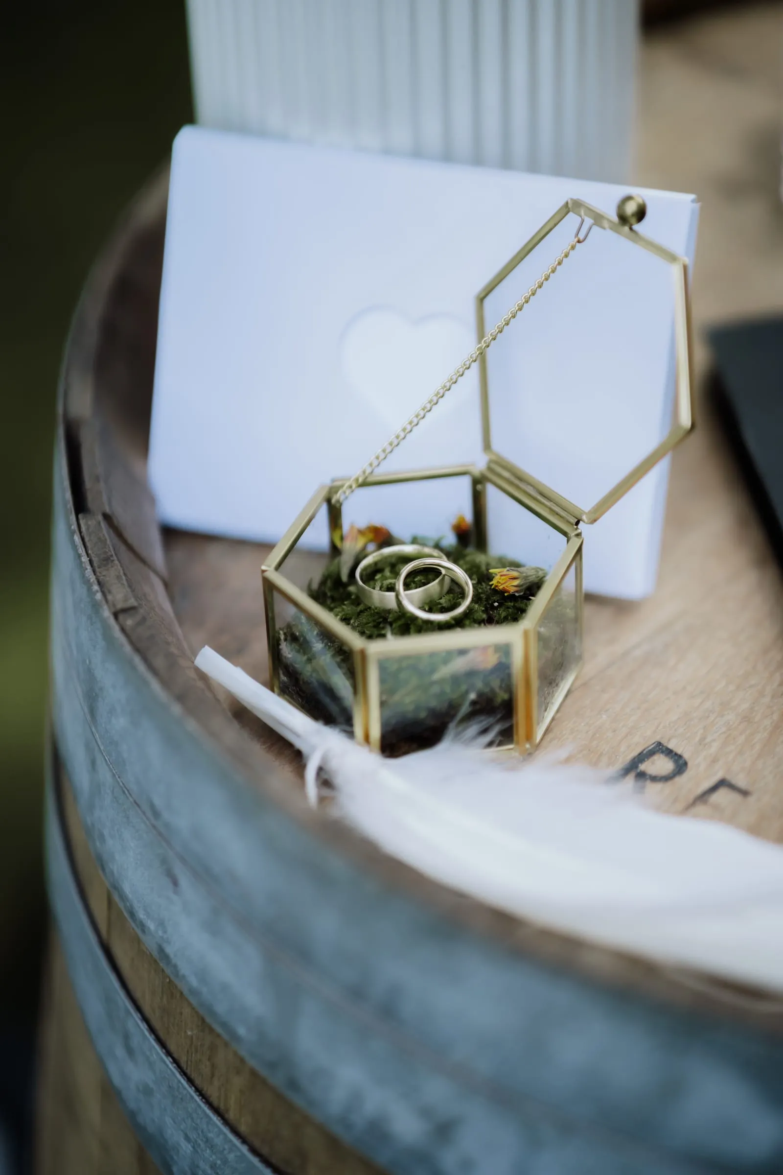 Die Ringe in der Glasschatulle auf dem Holzfass