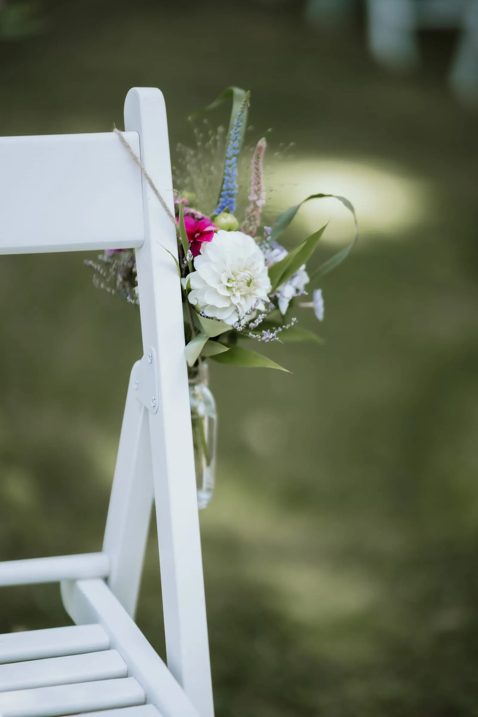 Ein weißer Stuhl mit Blumenschmuck am Rand