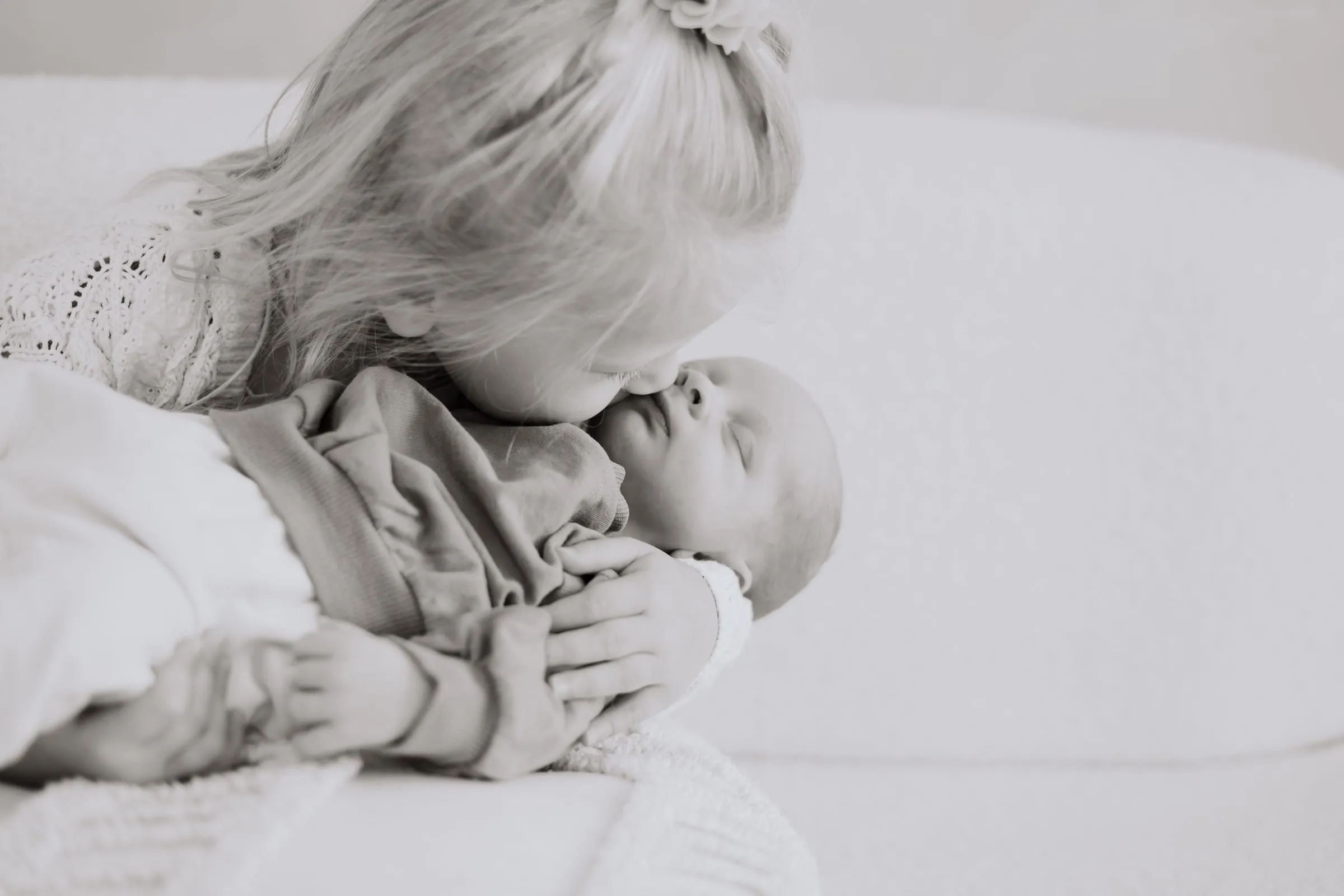 Die Mutter beugt sich über ihr Baby, in Schwarzweiß