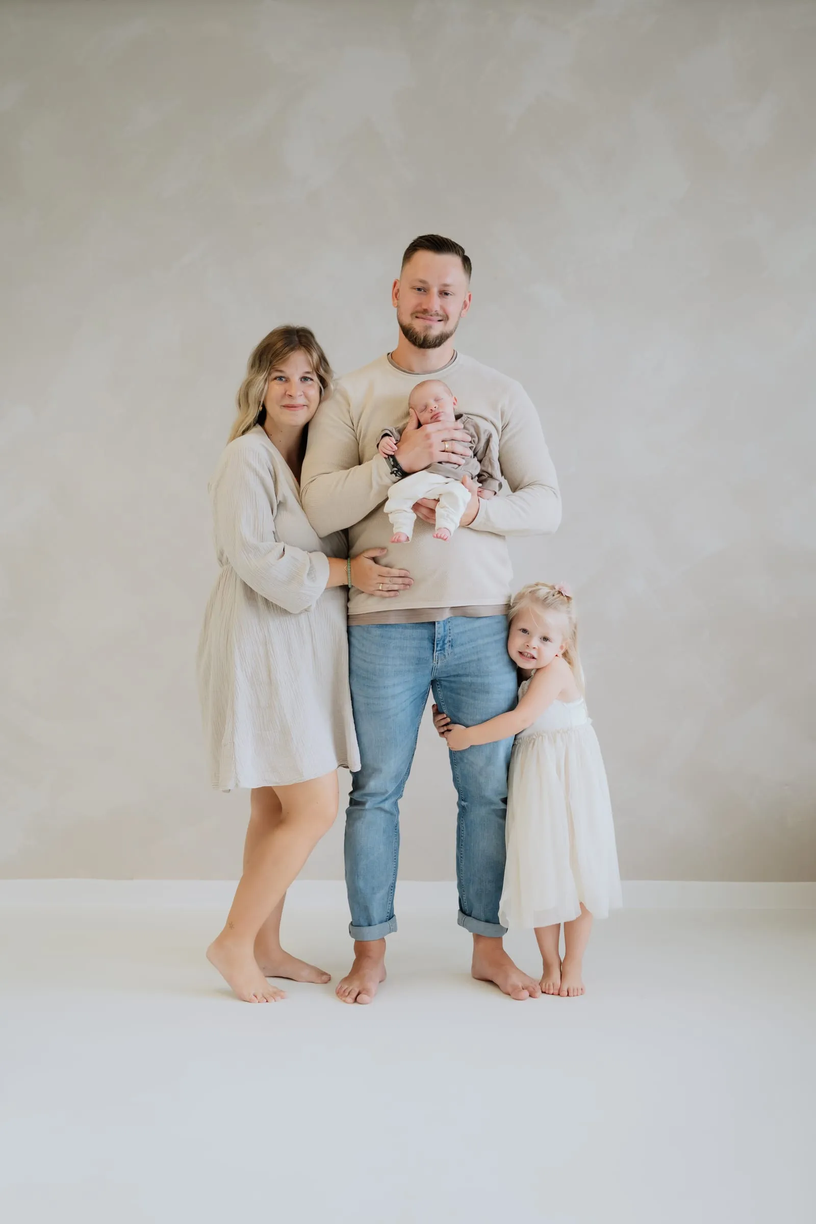 Die ganze Familie im Studio, das Neugeborene auf dem Arm