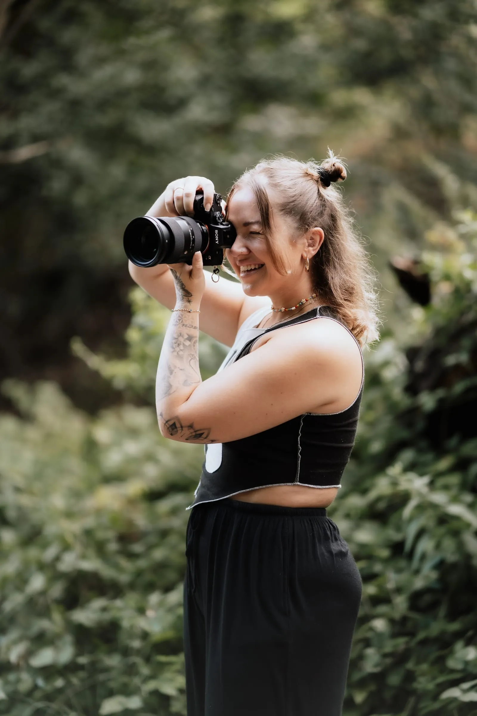 Xenia beim Fotografieren im Grünen, die Kamera vor dem Gesicht